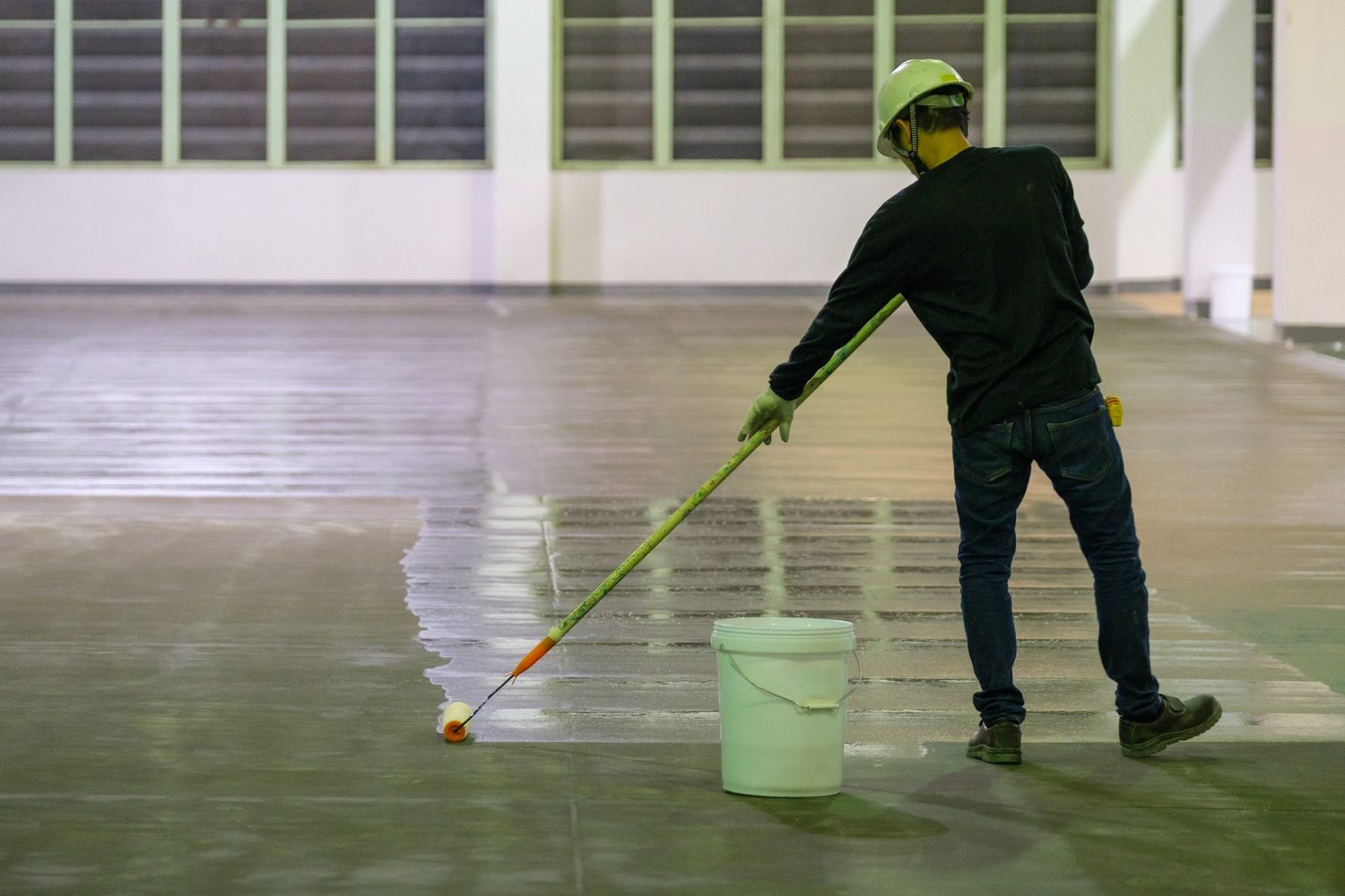 Worker applying floor coating